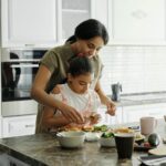 Image of a woman and her daughter preparing food in the kitchen.