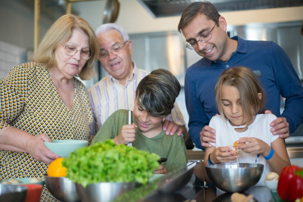 Uma família mista e diversificada se reúne em torno da cozinha para preparar uma refeição.